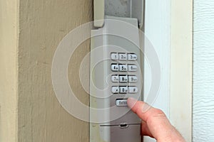 Hand entering code on keypad - garage door opener - home security