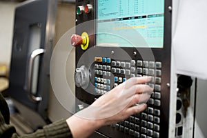 The hand enters data on the control panel of the lathe