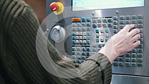 The hand enters data on the control panel of the lathe