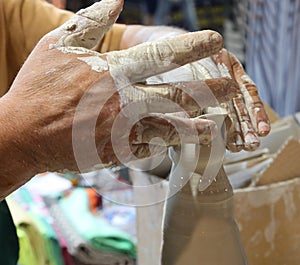 hand of the expert potter while shaping a clay pot using pressur