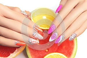 Hand with fashion manicure holding orange on white background