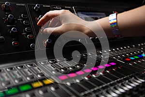 Hand of female audio engineer using sound mixer