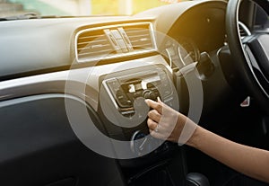 Hand female driver touching the screen and turning on car radio system,Button on dashboard in car panel