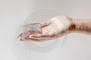 Hand of female holding hair fall or loss  is a problem of women on white background