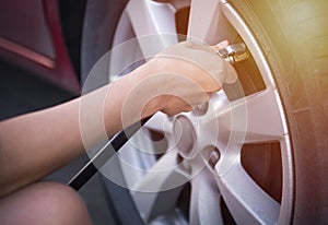 Hand of female inflate a tire before traveling. photo