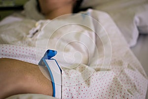 A hand of female patient with hospital bracelet while hospitalized and recovery. Close up