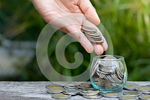 Hand of female putting coins in jar