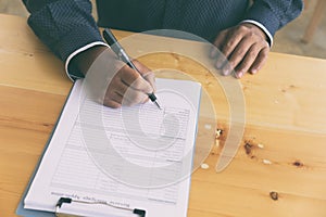 hand fill out reverse mortgage loan application on a clipboard.