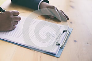 hand fill out reverse mortgage loan application on a clipboard.