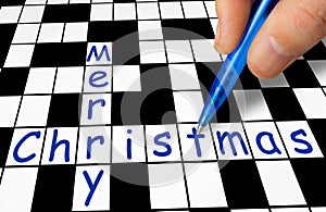 Hand filling in crossword - Merry Christmas