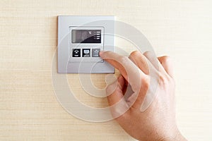 Hand with finger on air conditioner switch control
