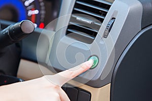 Hand finger press button eco mode inside car.