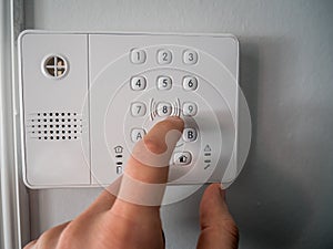 Hand and finger is pushing or pressing the alarm code