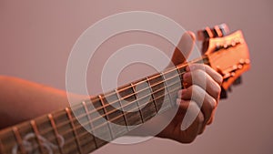 Hand and fingers holding chords and playing guitar neck