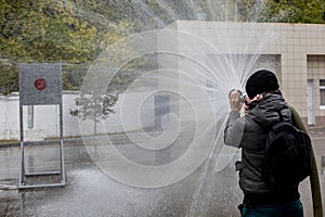 Hand with fire fighting nozzle. Water jet splashing from a fire fighting firehose nozzle