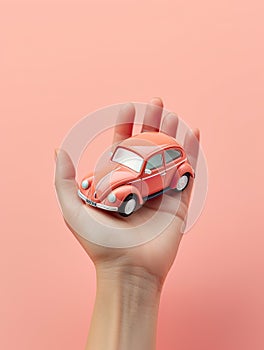 A hand firmly holds a toy car against a neutral background