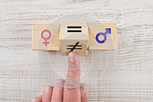 Hand flip wooden cube with unequal symbol changing to equal sign