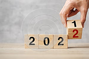 Hand flipping block 2021 to 2022 text on table. Resolution, strategy, plan, goal, motivation, reboot, business and New Year