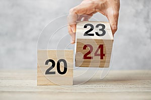hand flipping block 2023 to 2024 text on table. Resolution, strategy, plan, goal, motivation, reboot, business and New Year