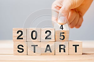 hand flipping block 2024 to 2025 START text on table. Resolution, strategy, goal, motivation, reboot, business and New Year photo