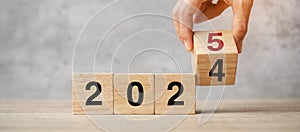 hand flipping block 2024 to 2025 text on table. Resolution, strategy, plan, goal, motivation, reboot, business and New Year photo