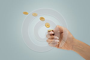 Hand is flipping a coin isolated on blue background