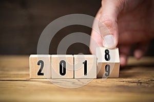 Hand flipping a cube, symbolizng the change from 2018 to 2019