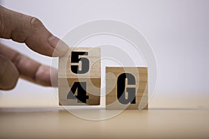 Hand flipping wooden cube for change 4G to 5G. Technology change transformation to high speed and internet of thing