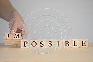 Hand flipping wooden cubes for change wording between impossible to possible.Mindset for career growth business.