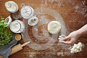 Hand and flour dough on wooden table