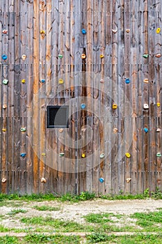 Hand and footholds on a wooden outdoor climbing wall