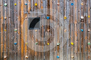 Hand and footholds on a wooden outdoor climbing wall