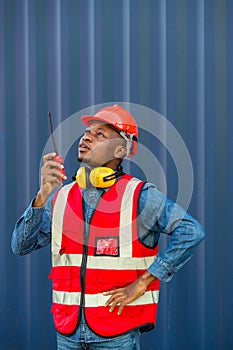 Hand Foreman holding walkie- talkie for control working at Container cargo site. Handheld walkie talkie for outdoor