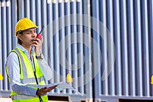 Hand Foreman holding walkie- talkie for control working at Container cargo site. Handheld walkie talkie for outdoor