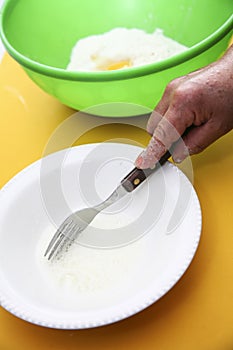 Hand with fork whiiping eggwhites in white small