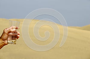 Hand and fresh water in desert