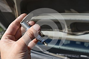 Hand Gapping a Spark Plug in Front of Car