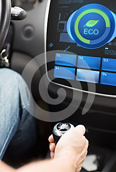 Hand with gearshift and car eco mode on screen