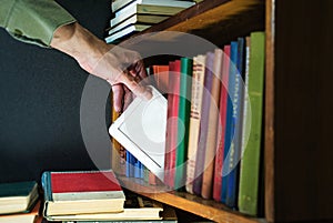 Hand gets ebook from the bookshelf. new technology concept