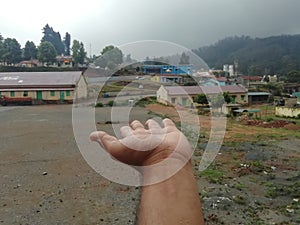 Hand getting drenched in rain Mountain view