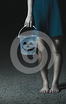 Hand girl holding a Halloween bucket.