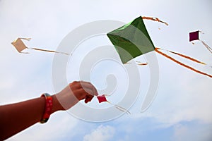 Hand of a girl raises a kite in a sky