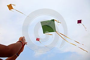 Hand of a girl raises a kite in a sky