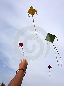 Hand of a girl raises a kite in a sky