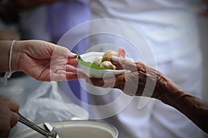 Hand give food to hands of a beggar