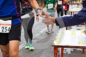 Hand give Minerals water to Unidentified runners