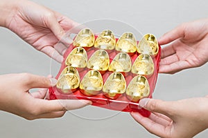Hand giveing gold ingot for Chinese New Year celebration