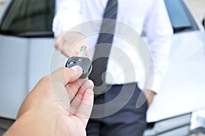 Hand giving a car key - car sale & rental service