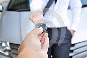 Hand giving a car key- car sale & rental service concept photo