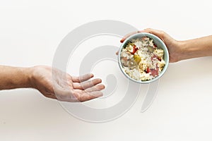 hand giving food bowl needy person. High quality photo